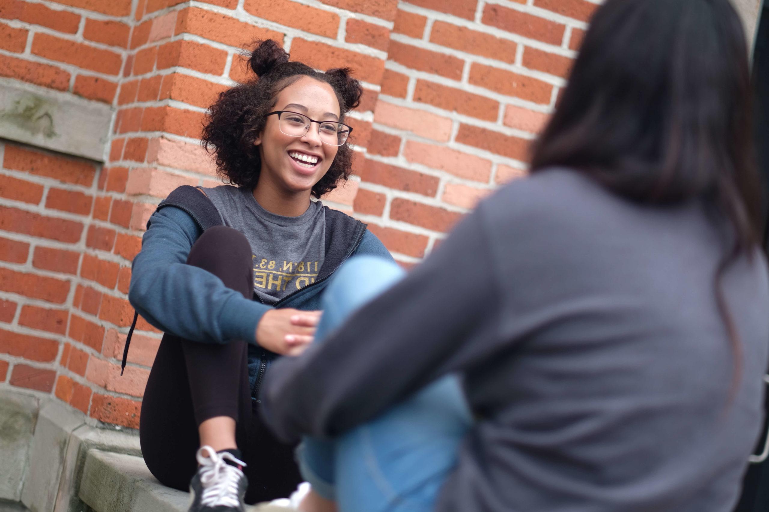 students talking on ledge of main